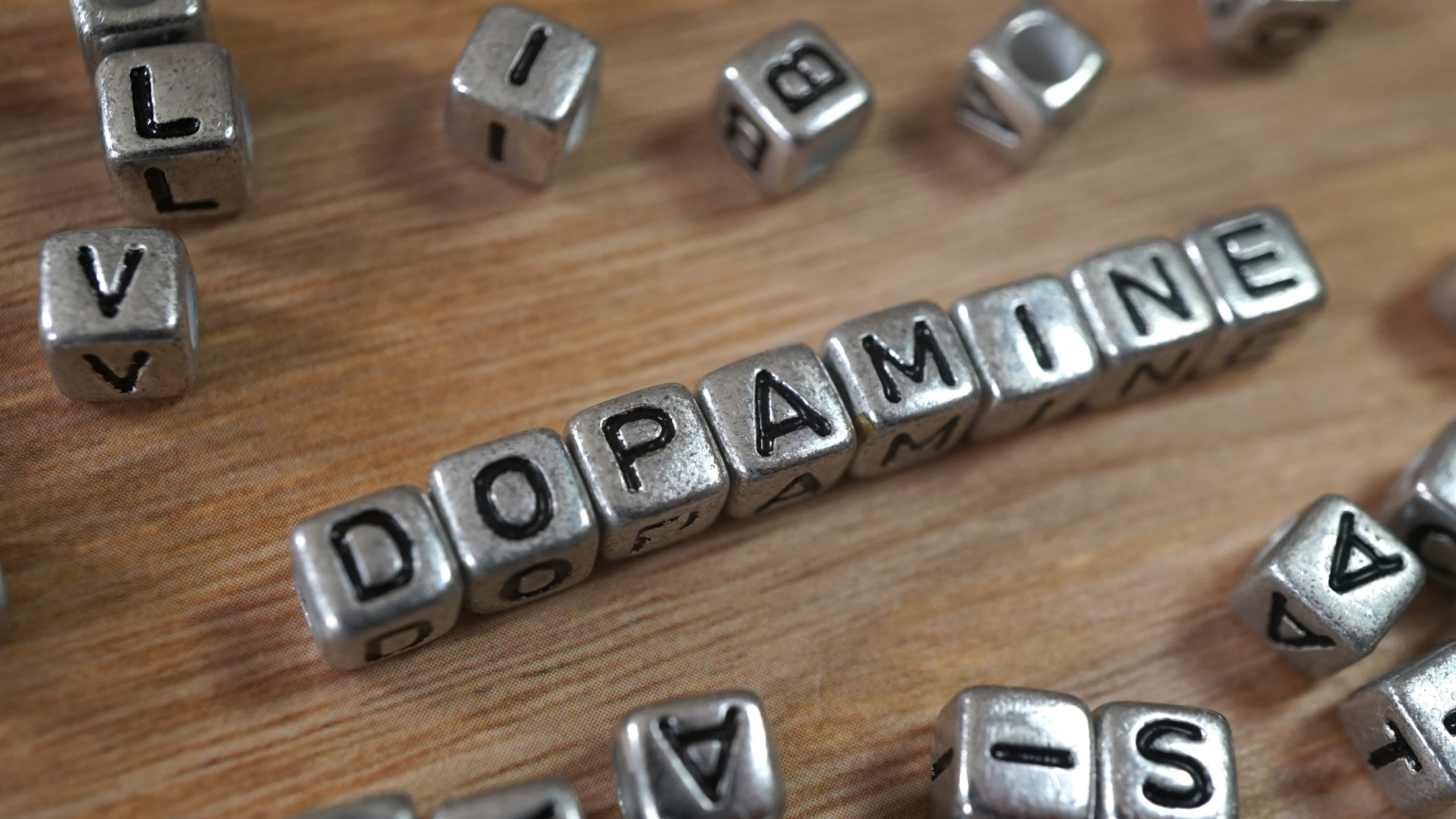 La parola "Dopamine" composta da dei piccoli cubi di metallo su un tavolo di legno
