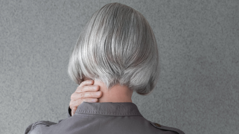 Una donna di spalle con i capelli grigi e un taglio a caschetto