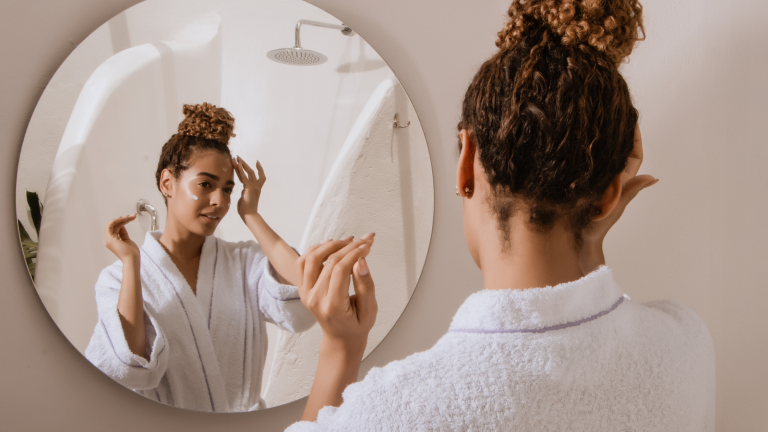 Una ragazza che si specchia mentre effettua la skincare