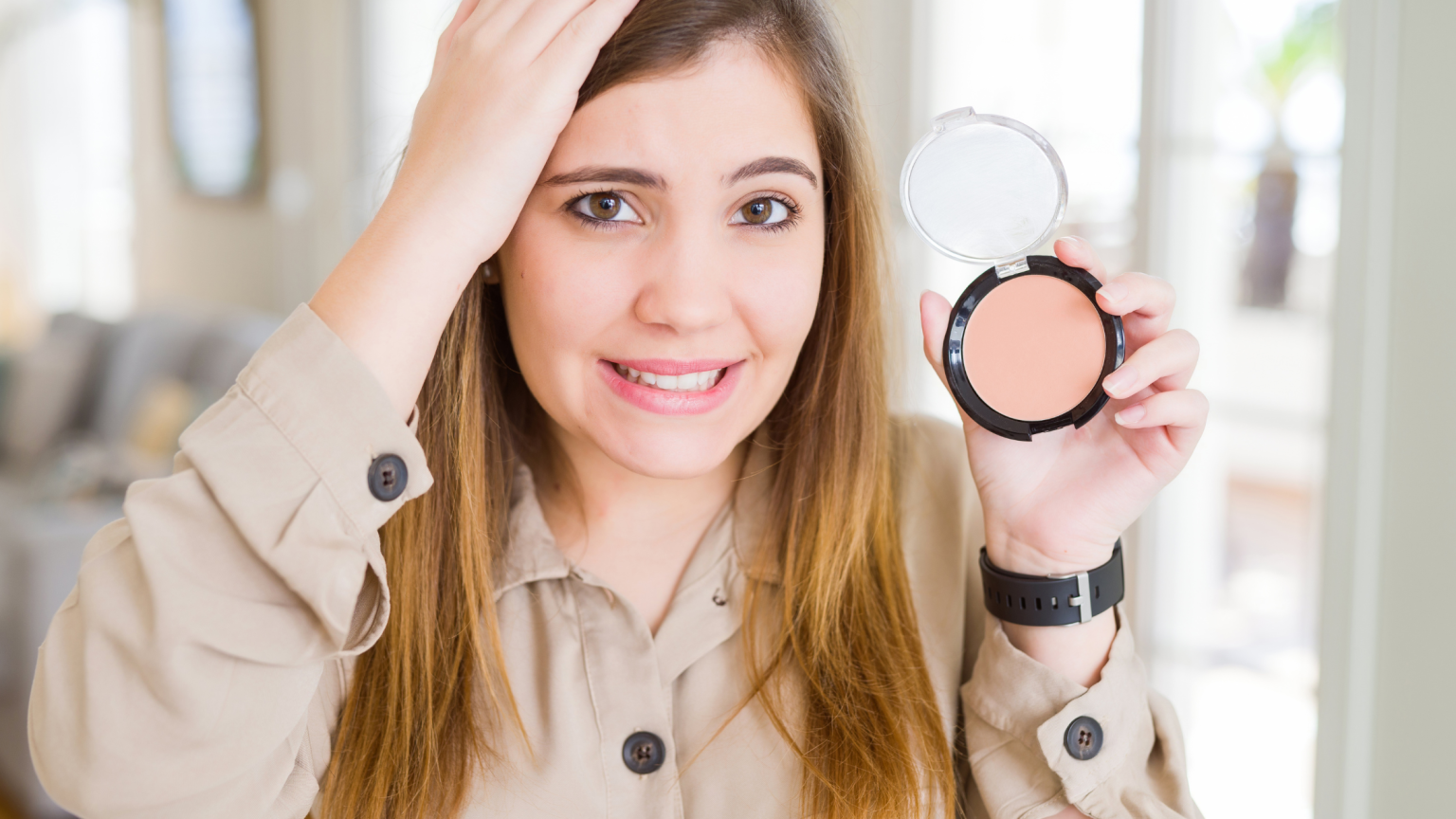 Una ragazza con un blush i9n mano e una mano sui capelli con il viso preoccupato