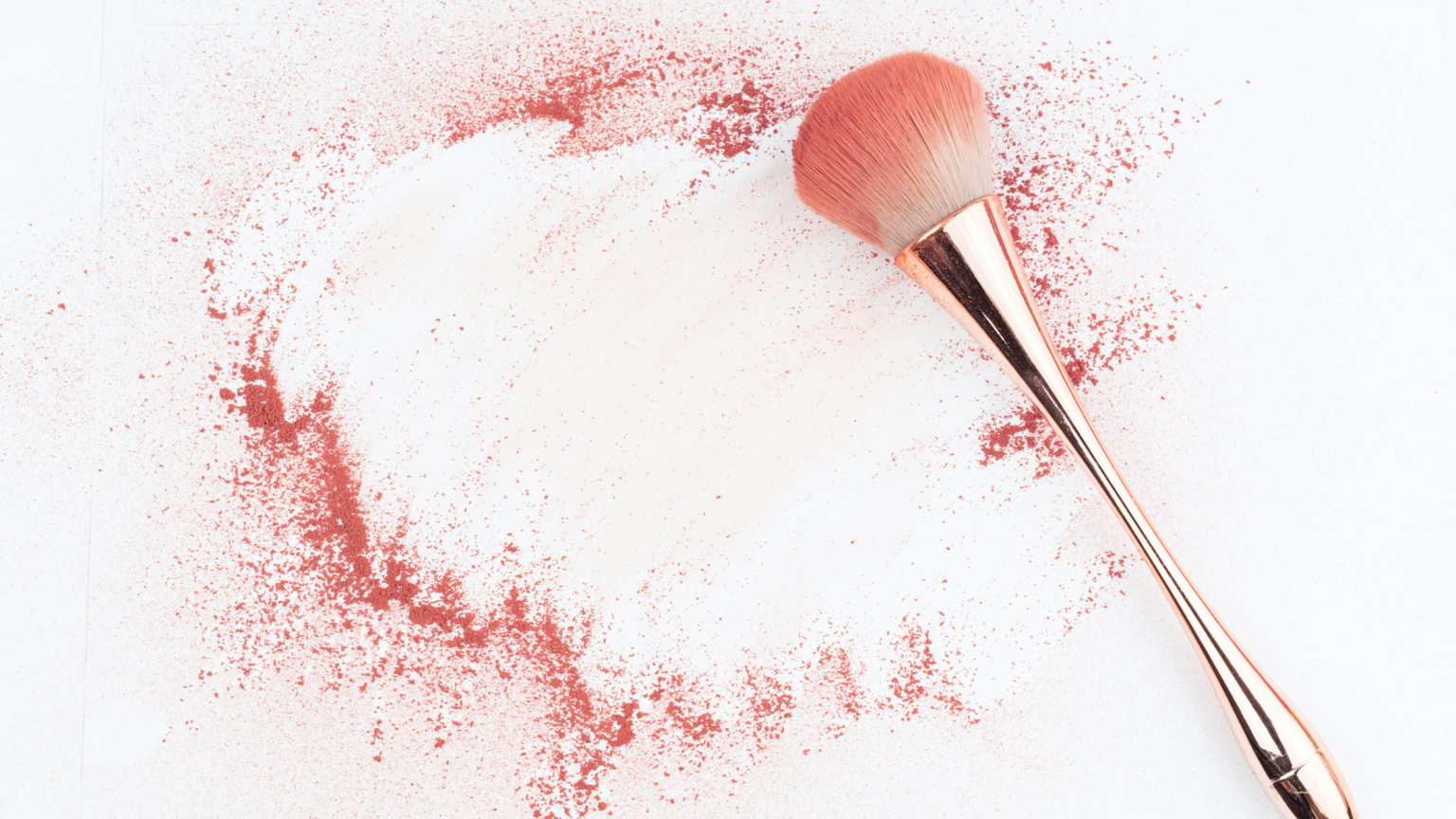 Un pennello da blush con della polvere rosata