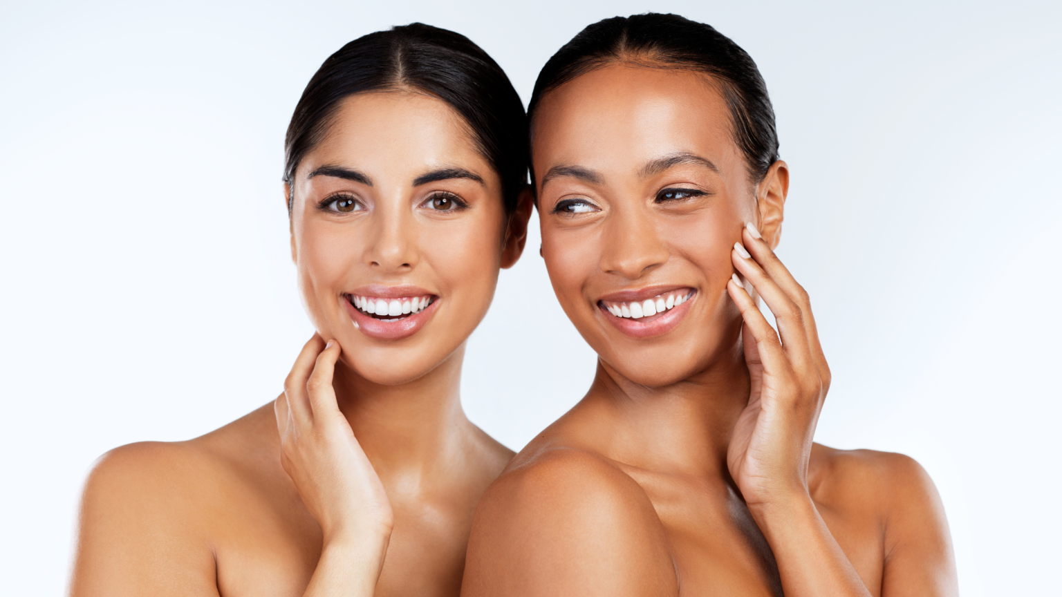 In primo piano due ragazze sorridenti e uno sfondo bianco