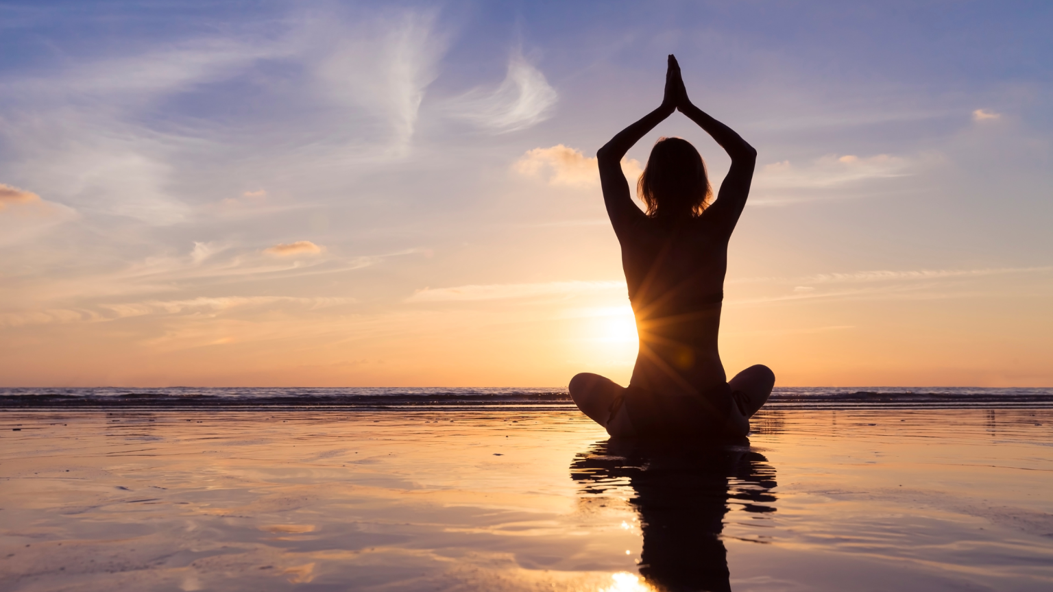 Una persona che fa yoga al tramonto