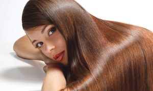 Una ragazza su sfondo neutro e dei capelli lunghi lucidi